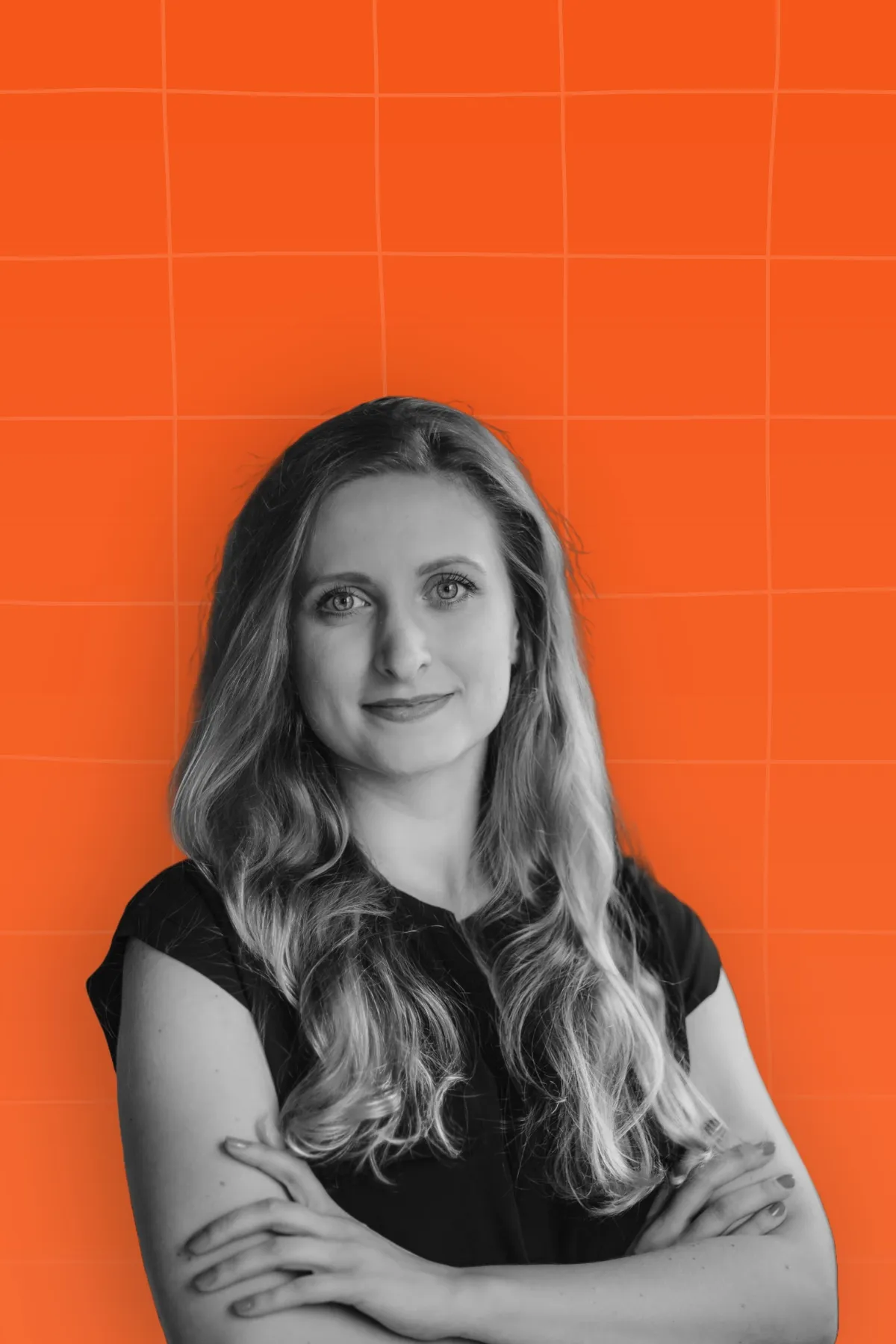 Black and white portrait of a smiling woman with crossed hand, placed on orange background with light orange pattern.
