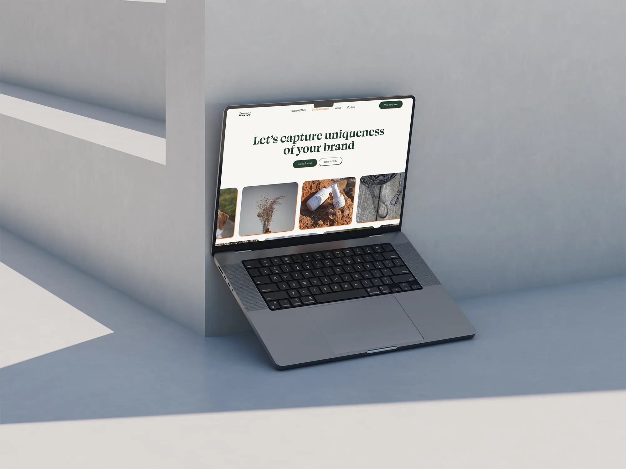 Macbook leaning on a concrete wall showcasing a past web project for Konst - social media agency.
