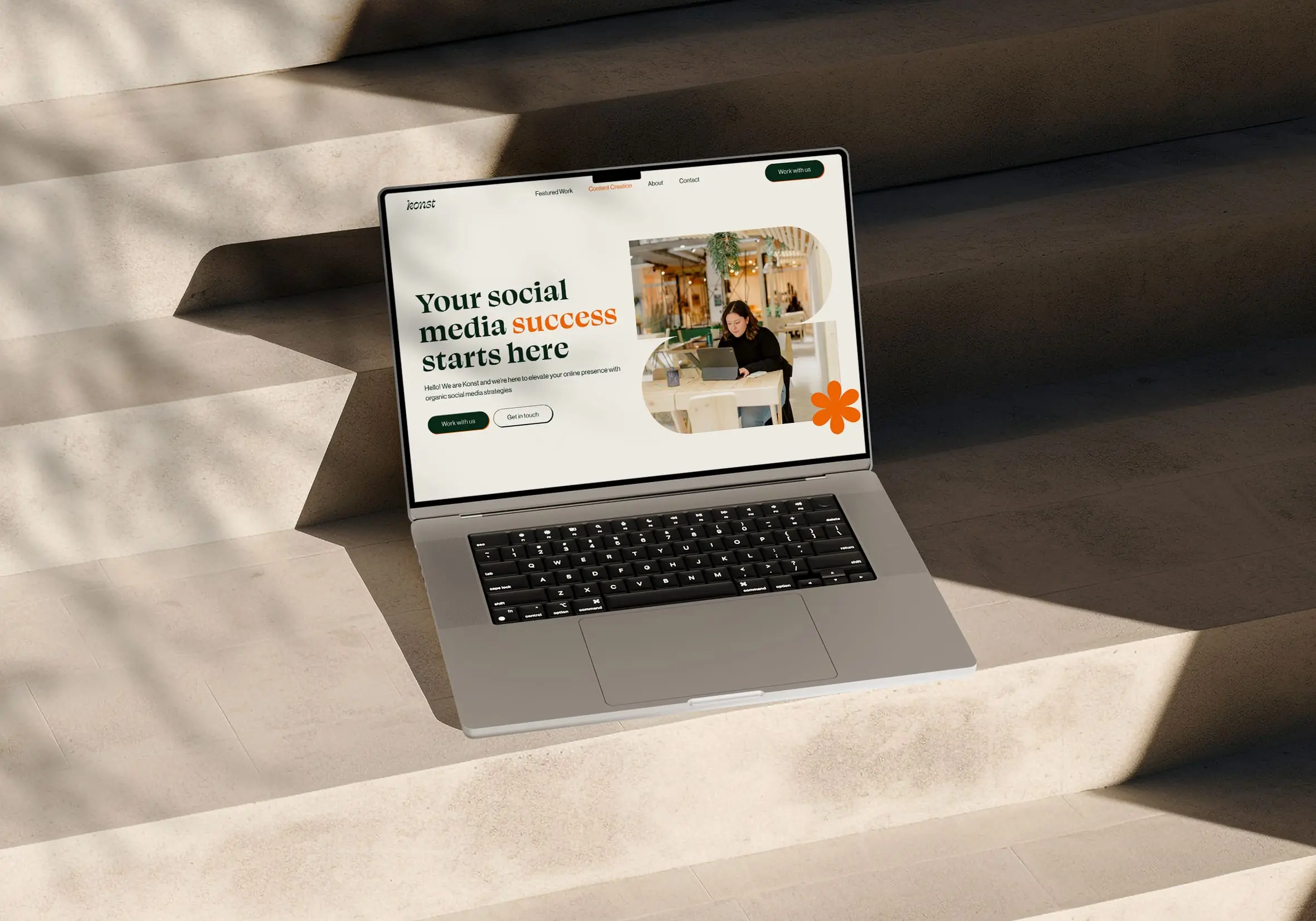 A Macbook placed on the marble stairs, showcasing kata.design work - Konst, a website for Social media agency based in Belgium