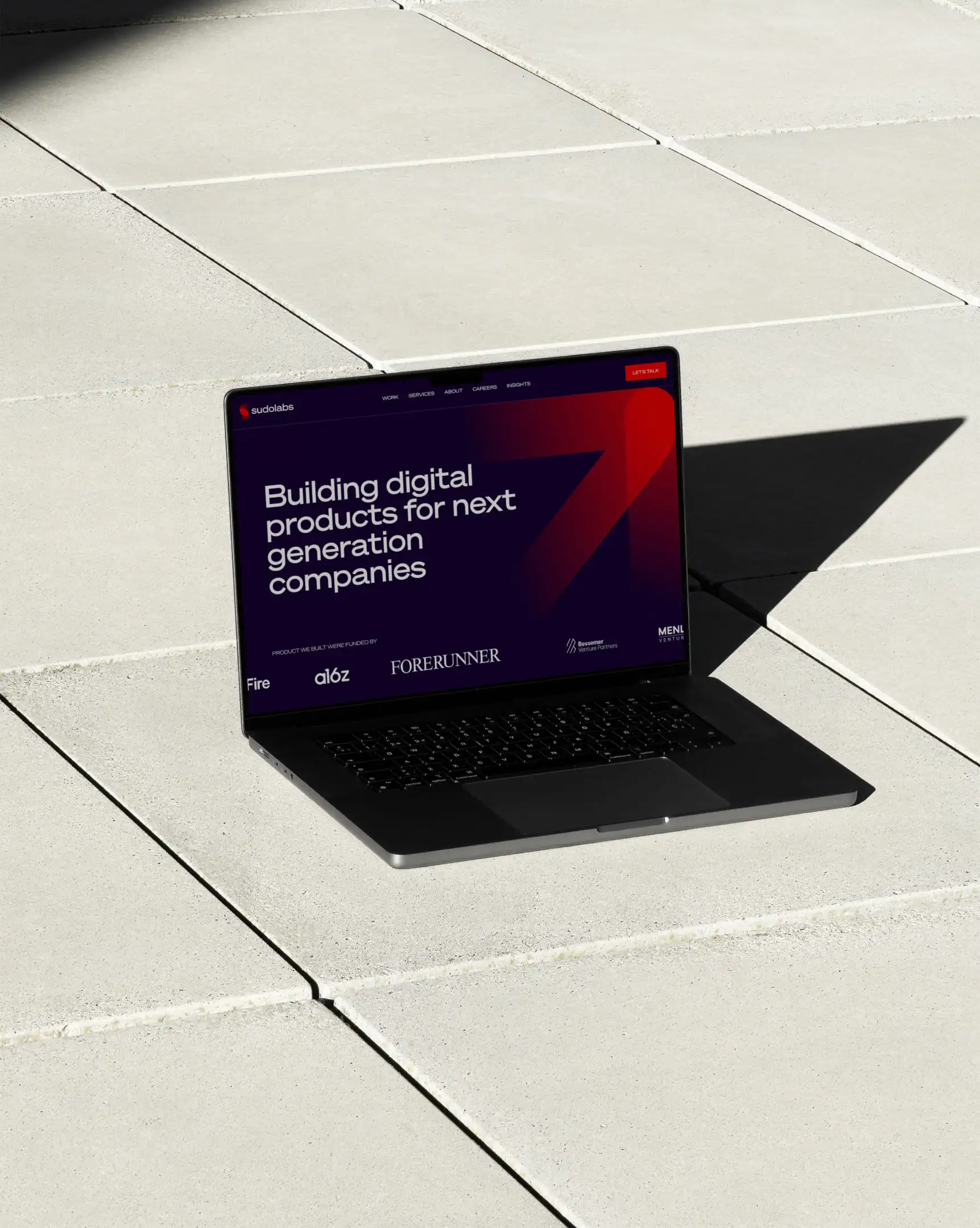 Macbook placed on a concrete tiles showcasing kata.design work -Sudolabs a digital studio for forward thinking companies
