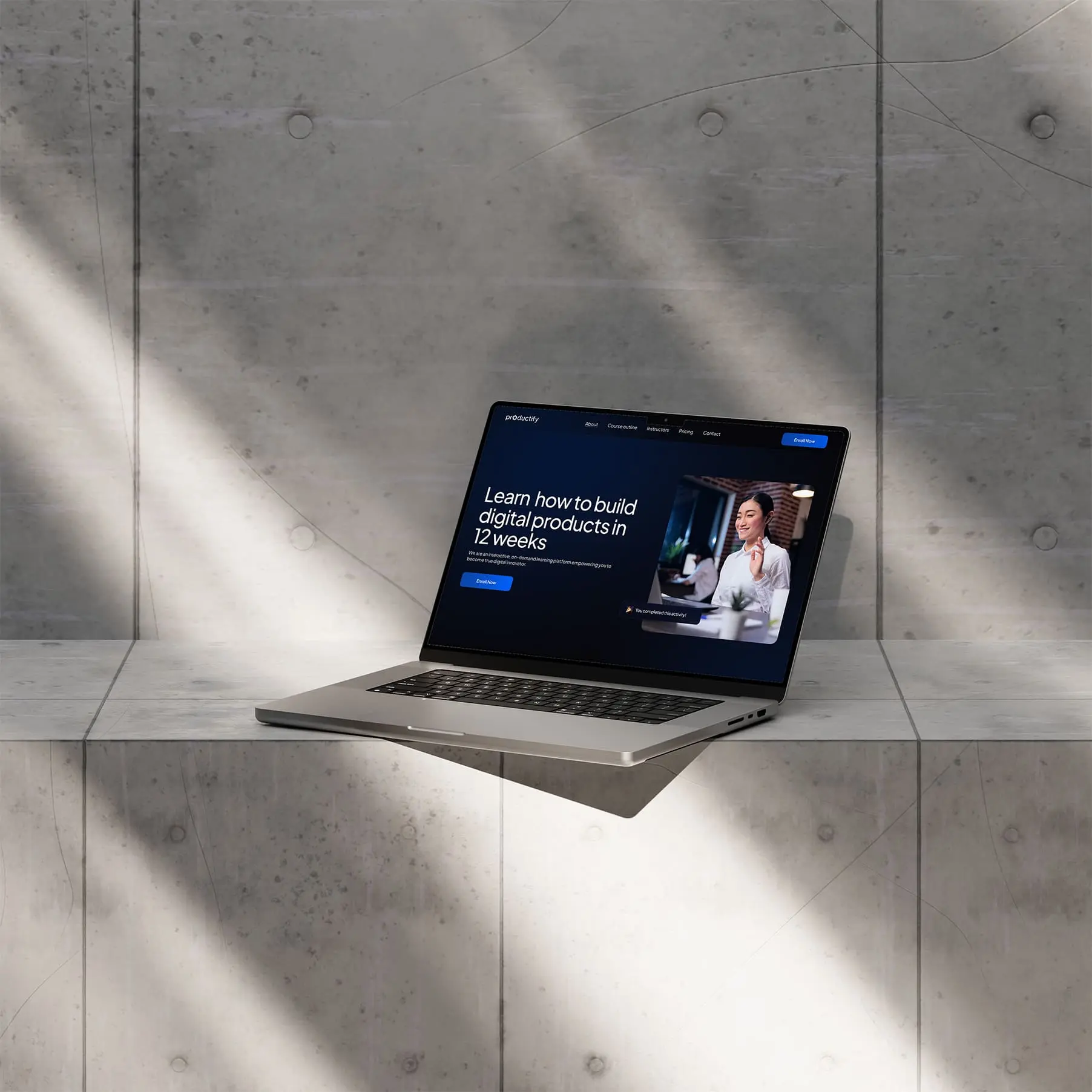 A Macbook placed on the concrete showcasing kata.design work - Productify an online learning platform for Product managers